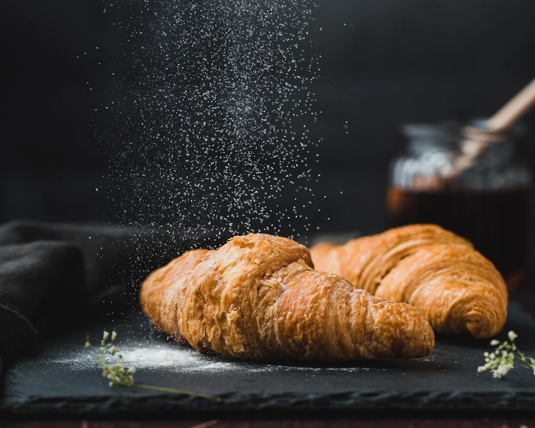 A golden croissant on a dark surface